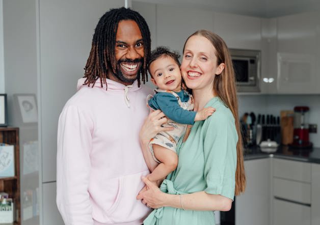 Couple holding their baby in their kitchen