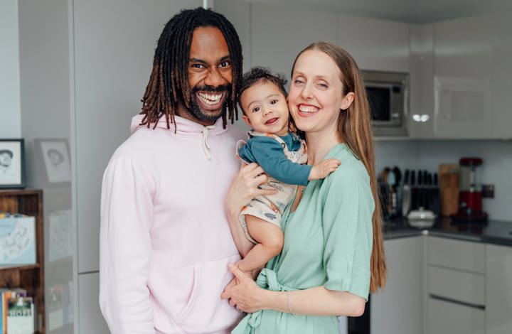 Couple holding their baby in their kitchen