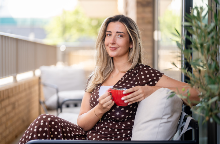 Woman sat on balcony of Shared Ownership home in London