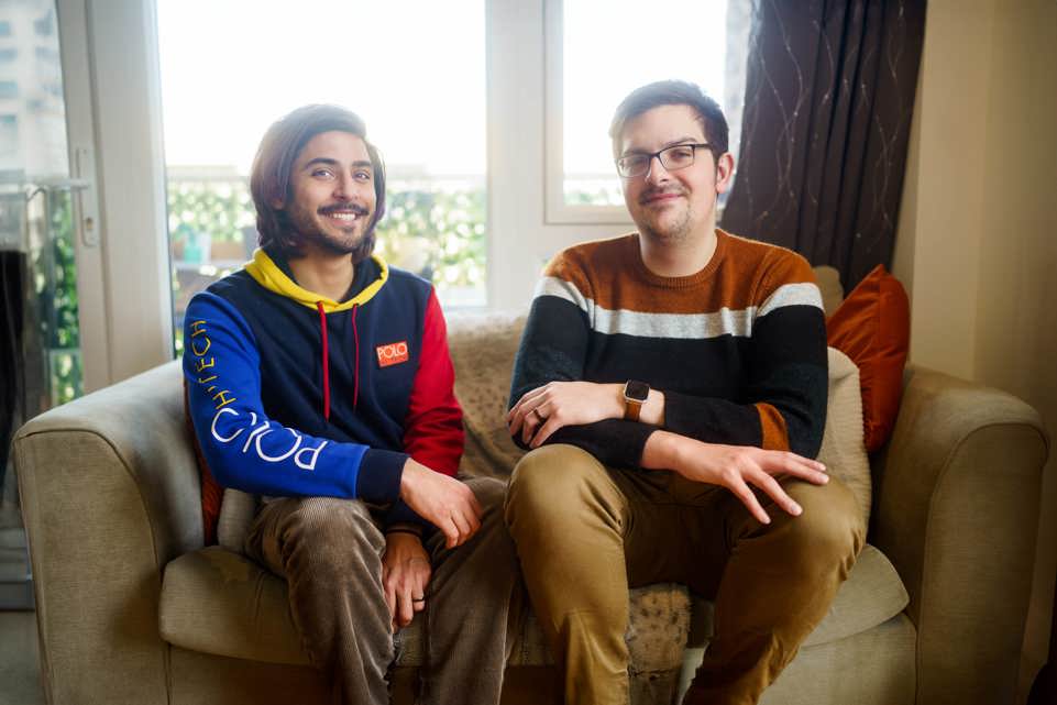 two men sitting on sofa