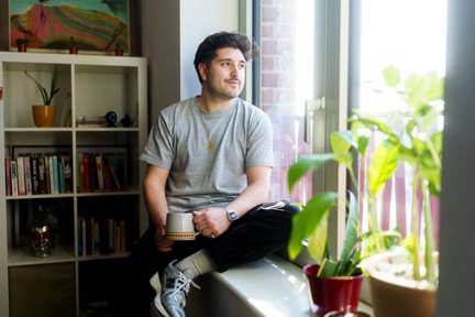 Clement sitting in window of Shared Ownership home at Macfarlane Place