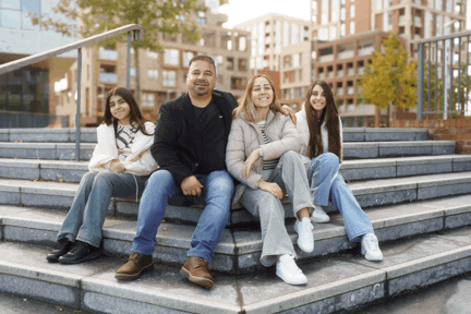 Family of four sat outside Southmere - Shared Ownership development