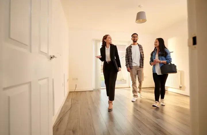 Estate agent showing a young couple around a house