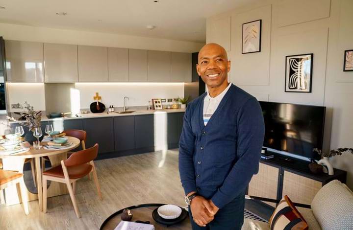man standing in his home with open-plan kitchen in background