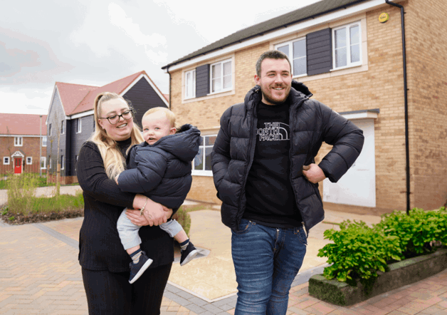 Two homeowners in from of their home