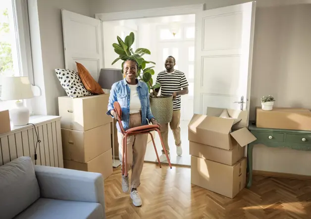 Couple moving boxes into new house