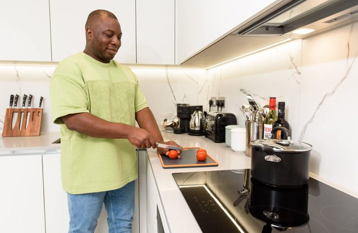 man cutting tomatoes in his kitchen