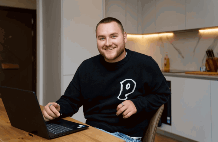 Man sat in kitchen of his home at Zone, Oval Village
