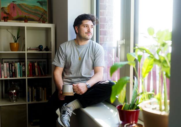 Homeowner sat on window sill of Shared Ownership home in Macfarlane Place