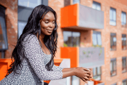 A woman leaning over a balcony of her Shared Ownership home