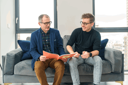 Two men sitting on a sofa of a Peabody show home