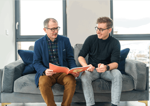 Two men sitting on a sofa of a Peabody show home