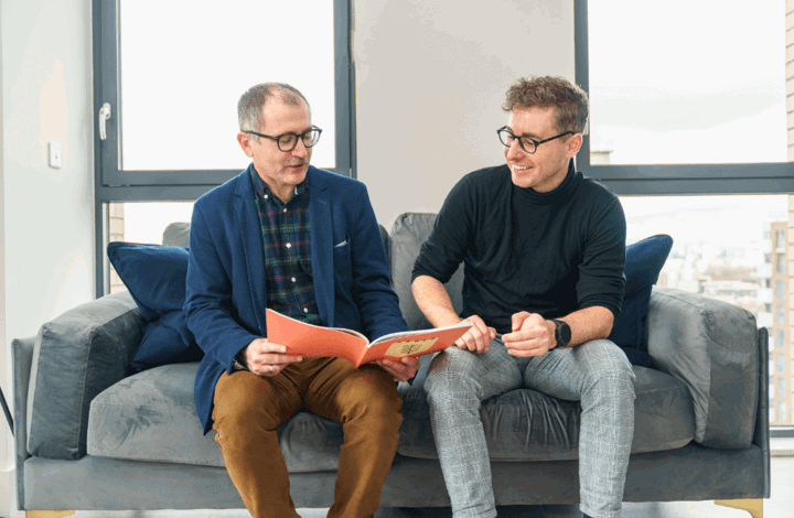 Two men sitting on a sofa of a Peabody show home