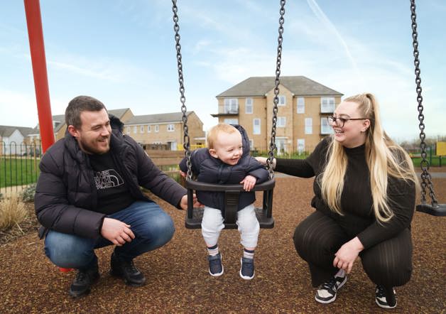 couple pushing baby on swing