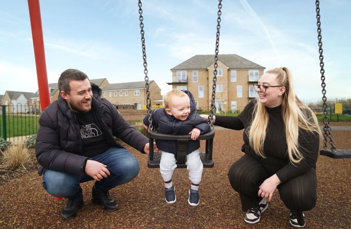 couple pushing baby on swing